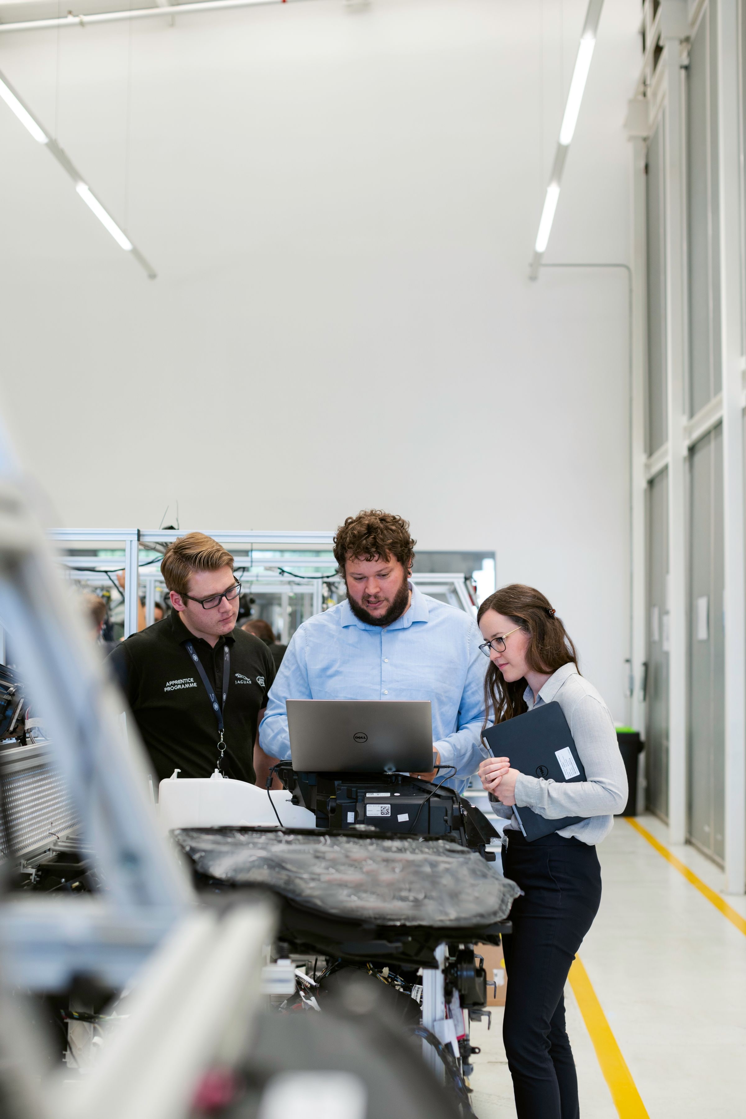 Trois ingénieurs échangent autour d’un projet en atelier
